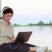Person working remotely on a laptop at a beach café in Bali, illustrating the lifestyle enabled by Indonesia’s remote worker visa.