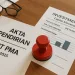 A PT PMA incorporation document on a desk alongside an Indonesian company stamp (cap perusahaan) and investment paperwork showing capital allocation.